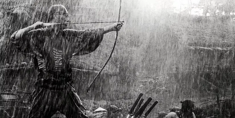 a man shoots a bow and arrow in the rain in seven samurai 1